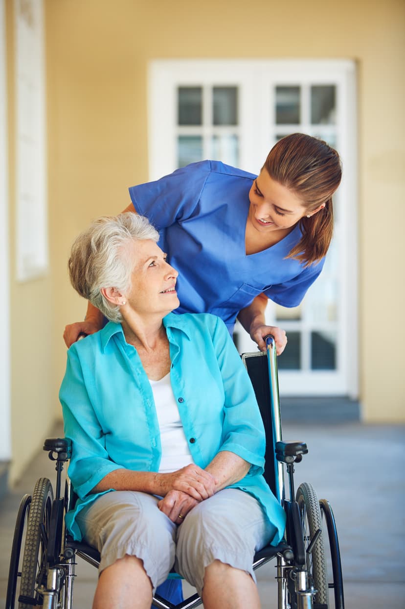 Senior sitting on wheelchair next to caregiver